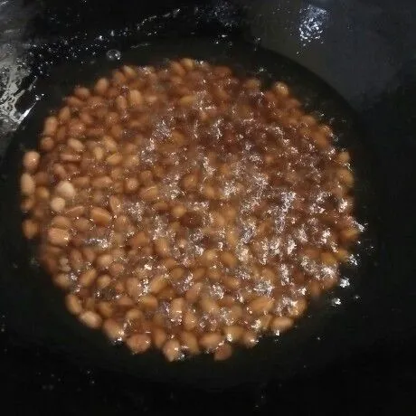 Panaskan minyak lalu masukkan kacang tanah dan goreng hingga agak kecoklatan.
