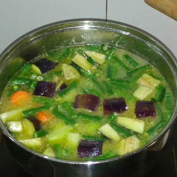 Masukkan sayuran wortel, kacang panjang, labu siam dan terong. Masak sampai sayuran setengah matang.