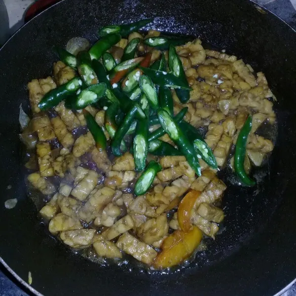 Masukkan cabe hijau, masak sampai cabe layu dan air menyusut.