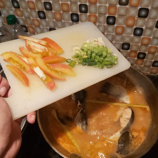 Tambahkan potongan tomat dan daun bawang.
