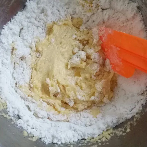 Tambahkan sedikit demi sedikit tepung terigu, tepung maizena dan susu bubuk yang sudah di ayak sebelumnya.