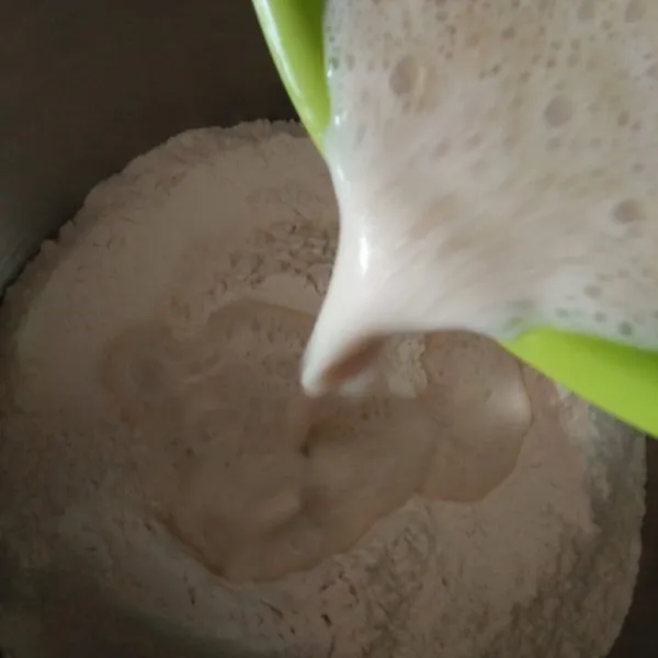 Tuang adonan biang ke dalam tepung, aduk hingga rata, tambahkan gula dan garam.