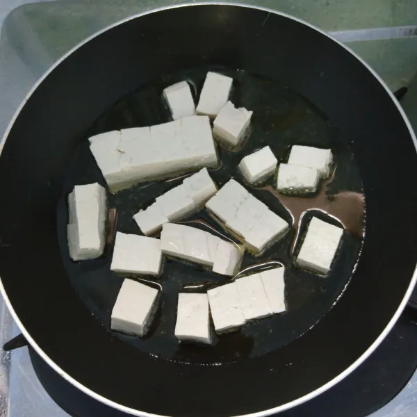 Potong dadu tahu. Kemudian goreng setengah matang.