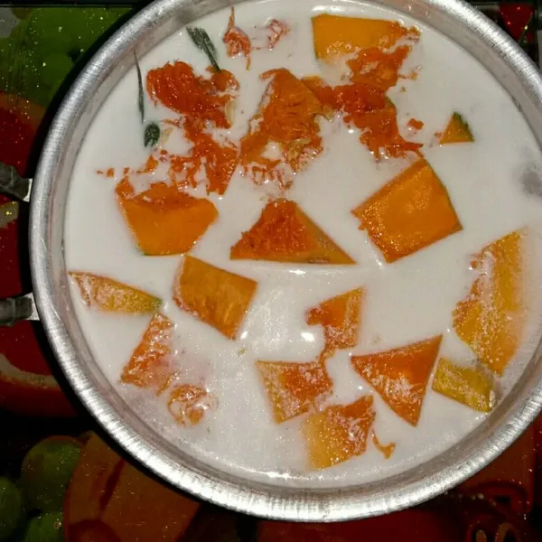 Rebus labu kuning bersama santan encer dan daun pandan sampai labu setengah matang.