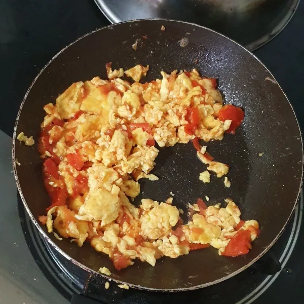 Aduk sebentar menggunakan api besar sampai jus tomatnya tercampur rata bersama telur. Hidangkan bersama nasi hangat.