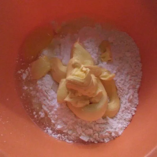 Tuangkan tepung terigu, gula halus, margarin, garam, dan kuning telur ayam. Aduk dengan spatula.