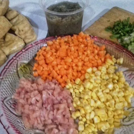 Siapkan bahan yang diperlukan, cuci dan cincang daging ayam, sisihkan. Potong dadu wortel dan sisir jagung manis. Iris halus daun bawang, haluskan bawang putih dan bawang merah.