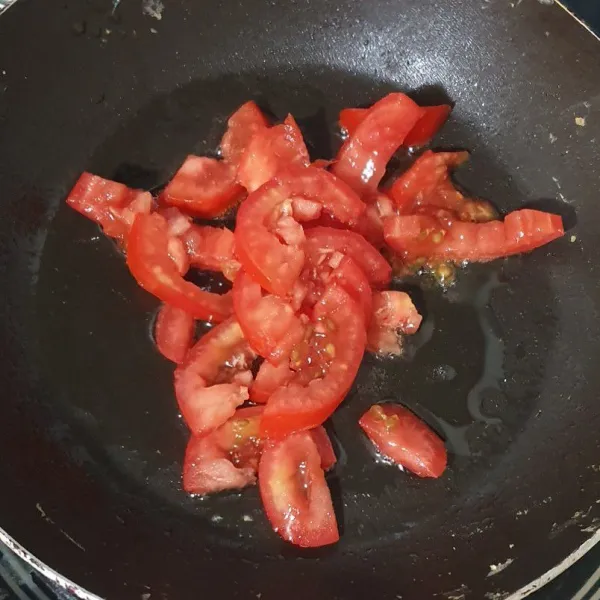 Potong tomat tipis/kecil kecil dan tumis menggunakan api kecil, tutup agar tomat mengeluarkan jusnya (bisa juga dengan ditekan2 tomatnya untuk membantu mengeluarkan jusnya).