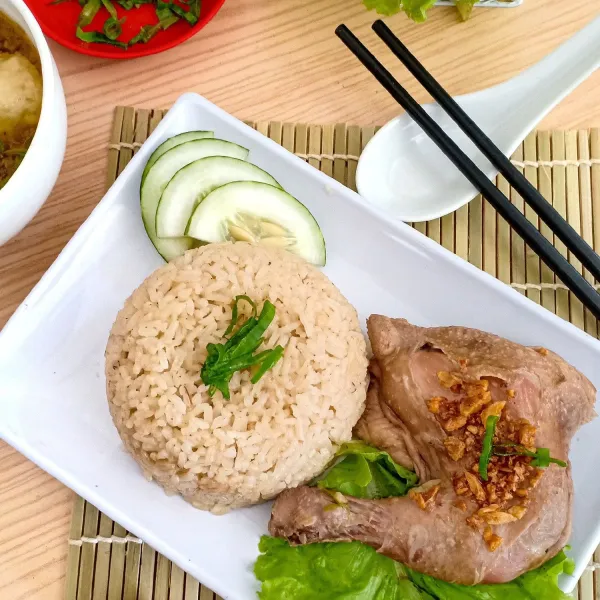 Sajikan nasi ayam hainam dengan kuah kaldu. Beri sedikit minyak bawang, minyak wijen di ayam agar makin mantap.