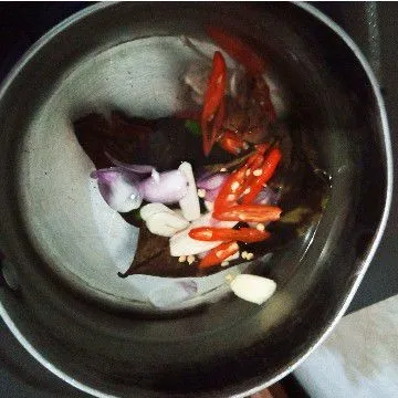 Rebus air kemudian masukkan bawang merah, bawang putih, cabai, lengkuas dan daun salam. Masak sampai mendidih.