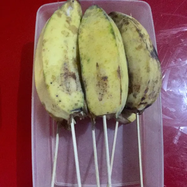 Tusuk setiap pisang dgn tusuk sate/ stik es cream lalu simpan di freezer selama kurleb 4 jam (saya semalaman).