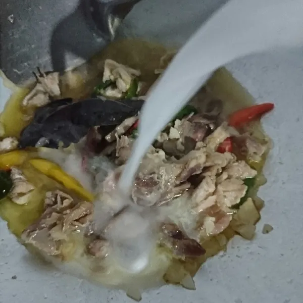 Setelah kuah surut, masukkan santan.