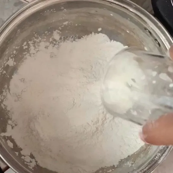 Masukkan tepung beras, tepung kanji, garam, gula pasir, dan air ke dalam wadah