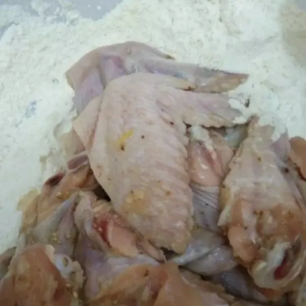 Dalam wadah lain, campurkan bahan tepung, aduk rata. Masukkan ayam yang sudah dimarinasi, baluri ayam dengan tepung hingga rata.