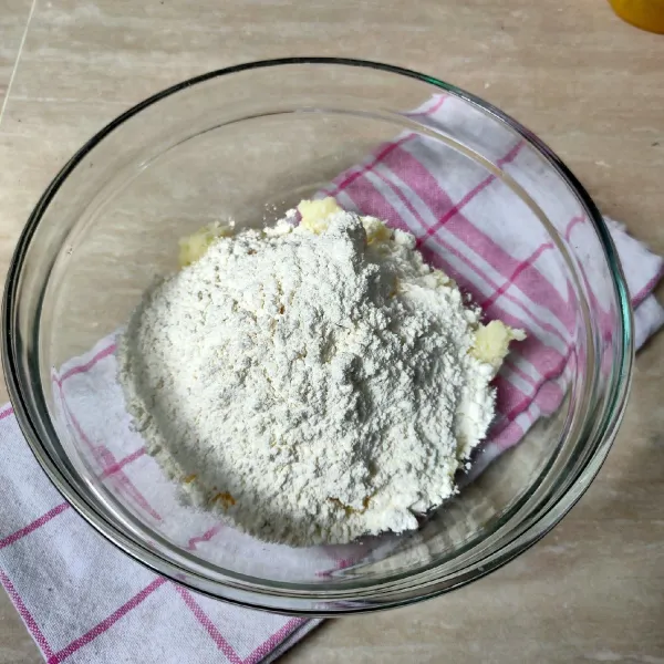 Tuang singkong halus dalam wadah, tambahkan margarin, telur, garam, baking powder dan tepung terigu. Aduk rata.