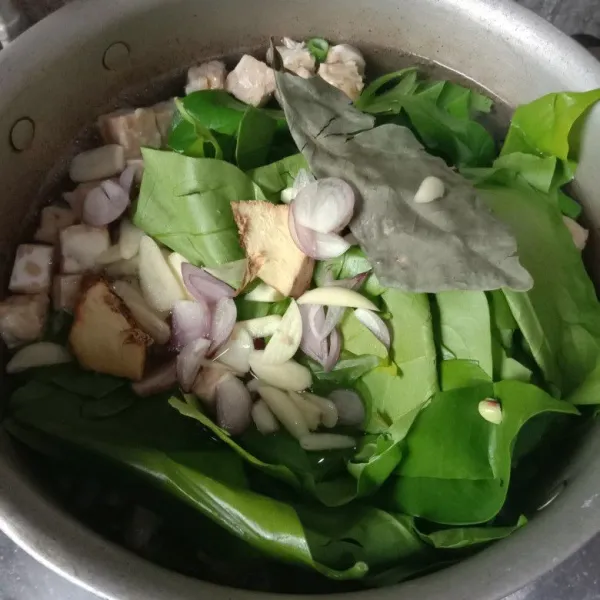 Masukkan semua sayur, tempe dan bumgu iris ke dalam panci, masak sampai setengah matang
