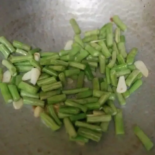 Tumis irisan bawang putih hingga harum, masukan irisan buncis.