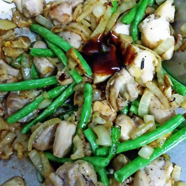 Tumis bahan bumbu iris hingga layu dan harum lalu masukkan ayam dan kacang panjang aduk rata tambahkan saus tiram dan kaldu bubuk.