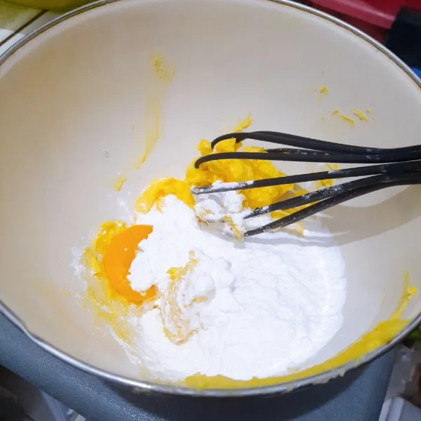 Masukkan margarin, kuning telur, gula halus ke dalam wadah. Kocok hingga tercampur rata sampai berwarna kuning pucat. Setelah itu, masukkan keju parut ke dalam adonan, kocok lagi hingga tercampur rata.