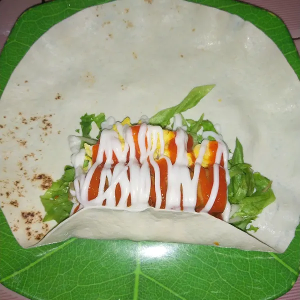 Beri saos sambal dan mayonise, lipat bagian bawah tortilla.