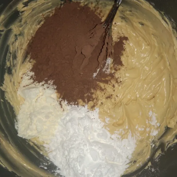 Kemudian masukkan tepung terigu, coklat bubuk dan susu bubuk. Aduk sampai adonan tercampur merata.