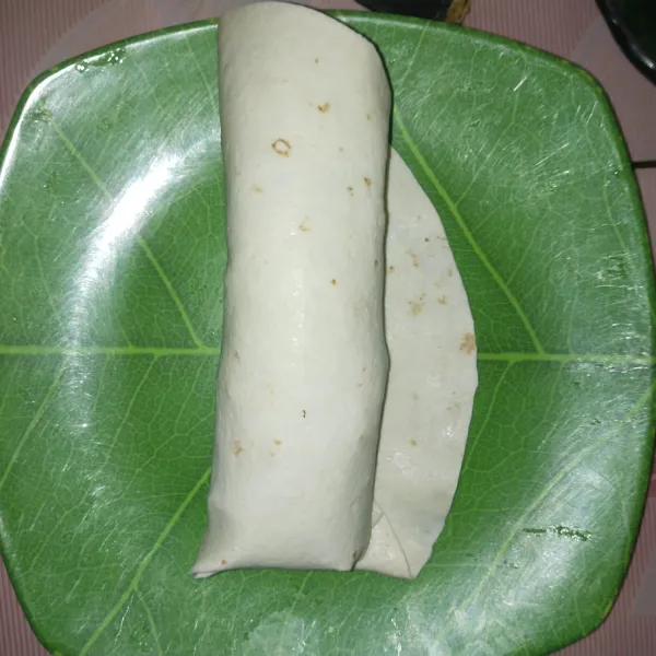 Gulung tortilla secara hati-hati dan pasikan tidak sobek agar saus tidak keluar.