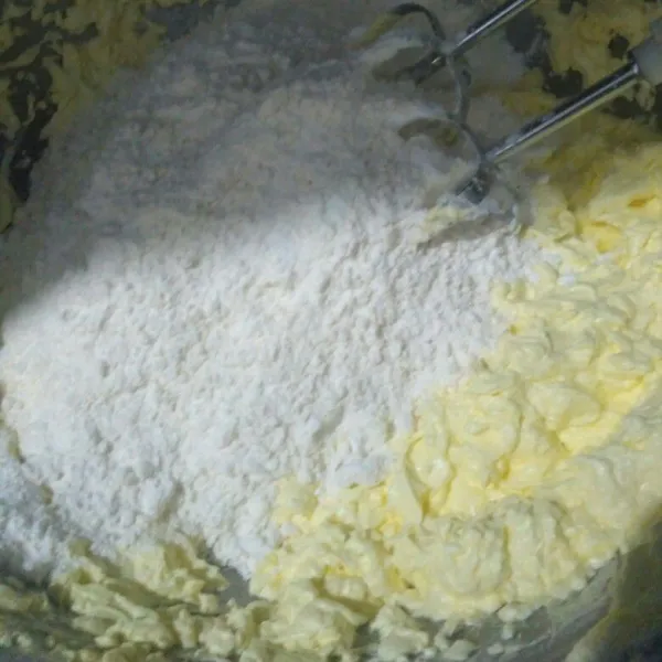 Setelah merata masukkan tepung terigu, susu bubuk dan maizena, vanilli bubuk. Aduk pakai spatula sampai tercampur rata.