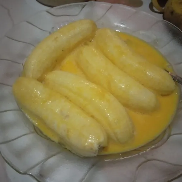 Kupas pisang dan balur dengan kocokan telur.