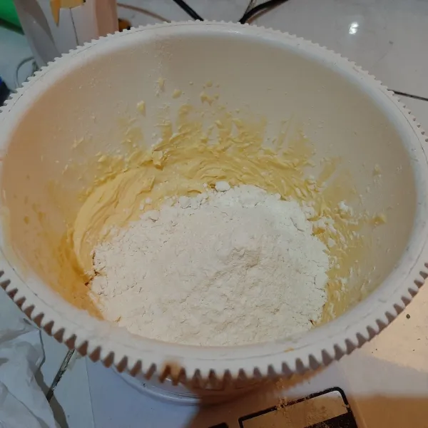 Tambahkan tepung terigu dan susu bubuk, aduk rata.