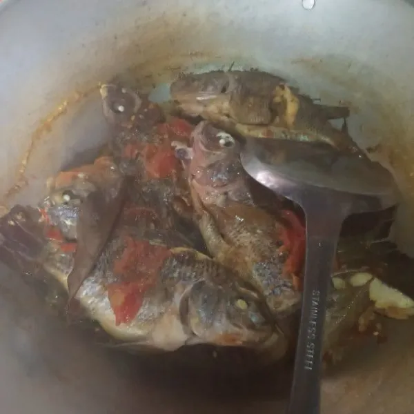 Masukkan ikan bawal, gula, garam, aduk rata dan ikan terendam dan tutup, masak sampai mendidih, lalu buka.