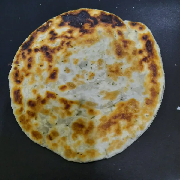 Panggang roti paratha hingga matang dan kecoklatan. Lalu lempar-bolak balik beberapa kali dan tepuk-tepuk selagi hangat.