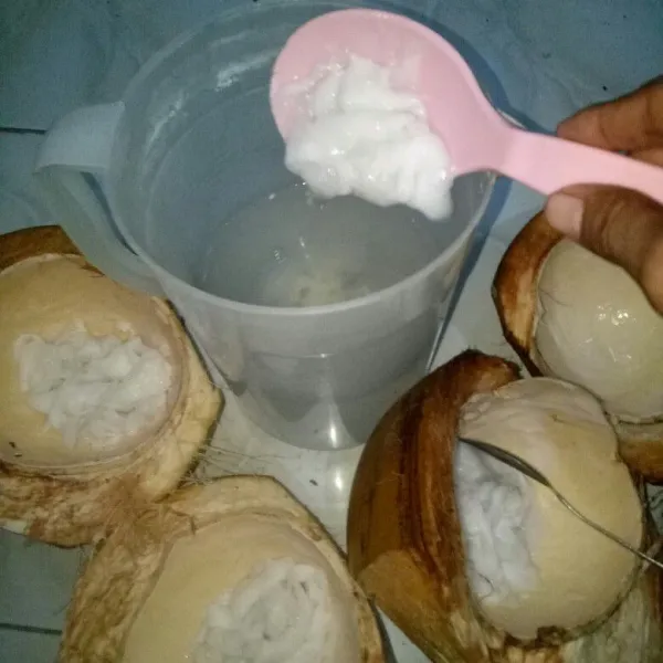Masukkan buah kelapa yang sudah dikerok ke dalam wadah air kelapa.