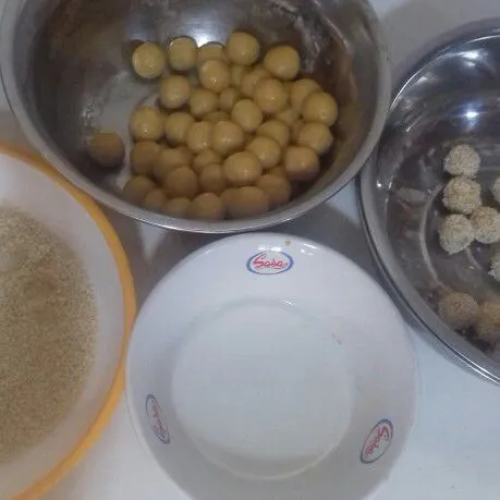 Siapkan air dan wijen di tempat terpisah. Celupkan bulatan ke air, balur ke wijen. Lakukan hingga selesai.