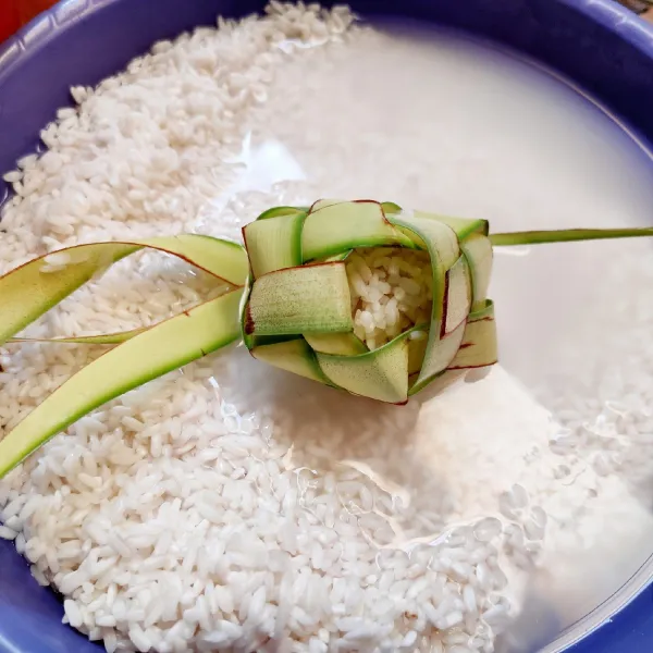 Masukkan beras ketan ke dalam kulit ketupat (2/3 bagian isi). Lakukan dampai semua kulit ketupat terisi.