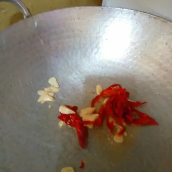 Tumis bawang putih hingga harum, masukan cabe merah, aduk rata.