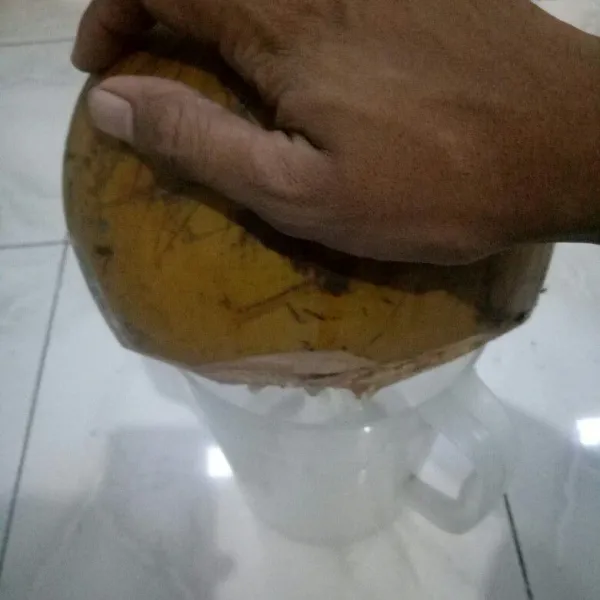 Tuang air kelapa ke dalam wadah.