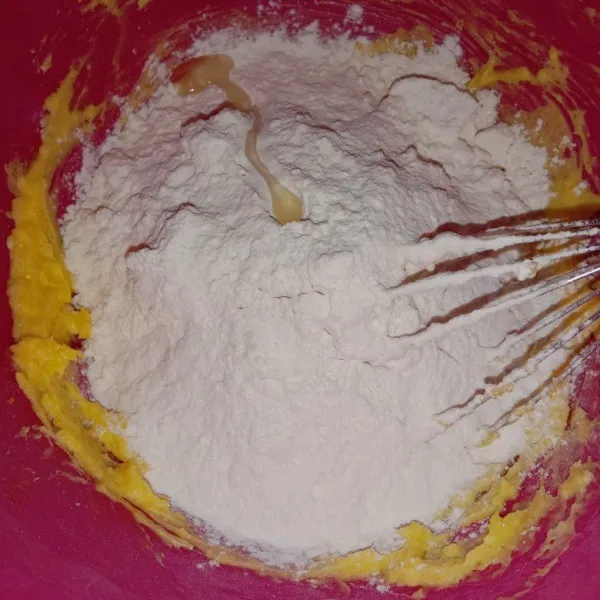Masukkan tepung terigu, maizena dan sedikit perisa vanilla lalu aduk rata menggunakan spatula hingga menjadi adonan yang bisa dibentuk.