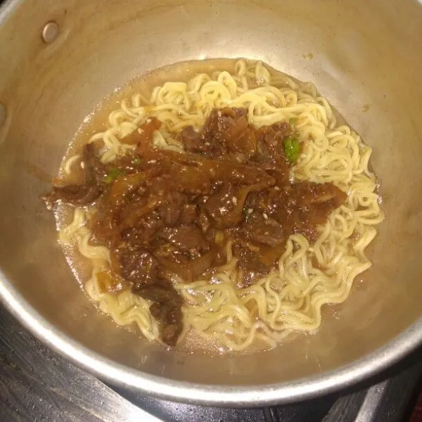 Rebus mie, tiriskan, sisakan sedikir air rebusan mie,l alu masukkan daging yang sudah matang, koreksi rasa.