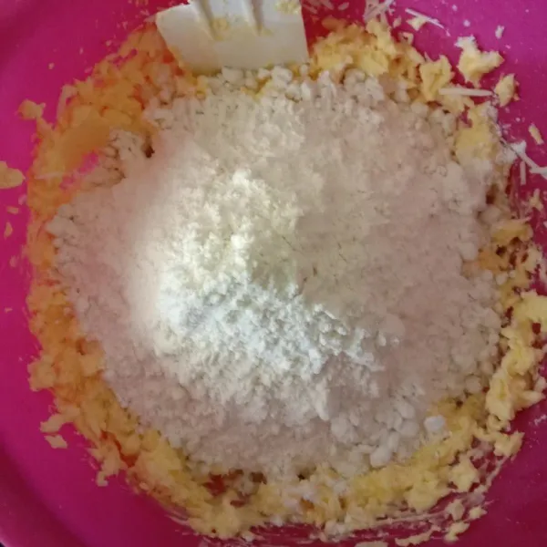 Tambahkan tepung terigu dan tepung maizena yang sudah diayak, aduk menggunakan spatula hingga adonan tercampur rata.