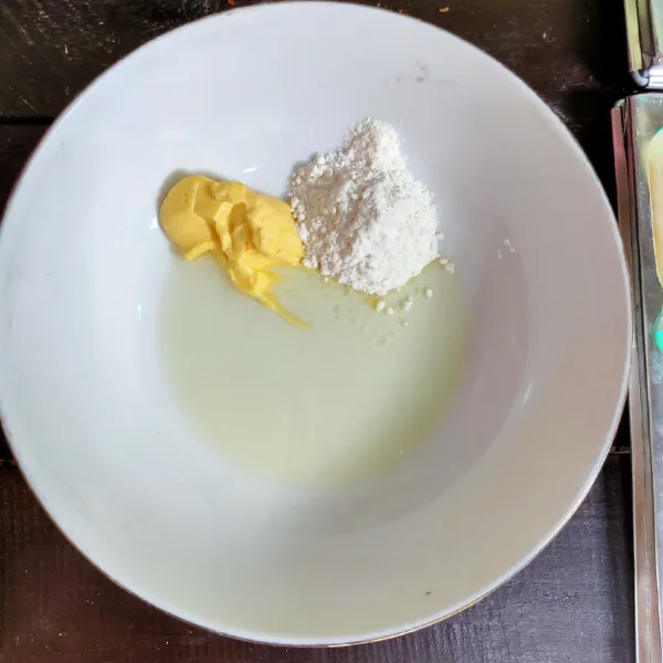 Pertama, siapkan bahan olesan loyang terlbih dahulu, tuang dalam wadah: Margarin, minyak dan tepung terigu, aduk rata.