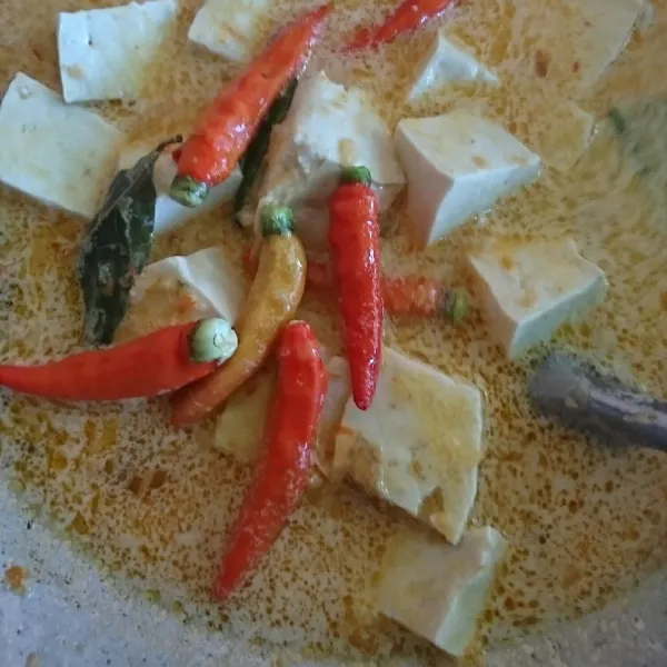 Masukkan tahu, garam, gula, cabai rawit utuh dan kaldu bubuk. Aduk rata.