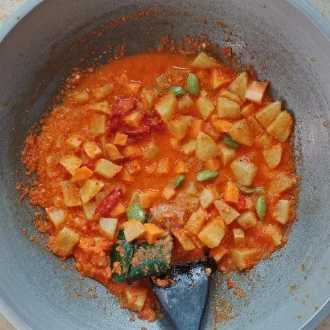Masukkan air, kentang, wortel, cabai merah, petai, daun salam, daun jeruk dan lengkuas. Masak hingga air menyusut.