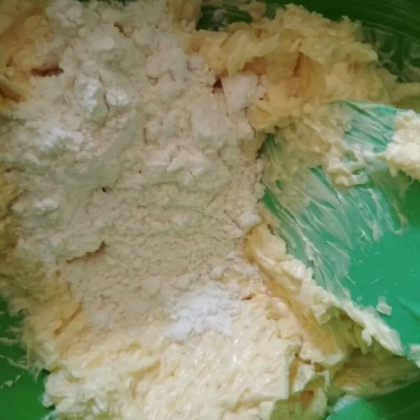 Tuang bertahap campuran terigu, maizena, dan susu bubuk aduk hingga tercampur rata.