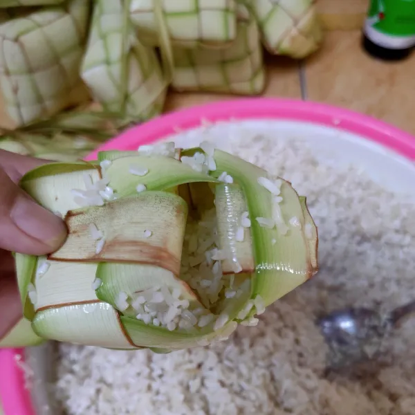 Isikan beras kedalam kulit ketupat, sampai memenuhi 3/4 wadahnya.
