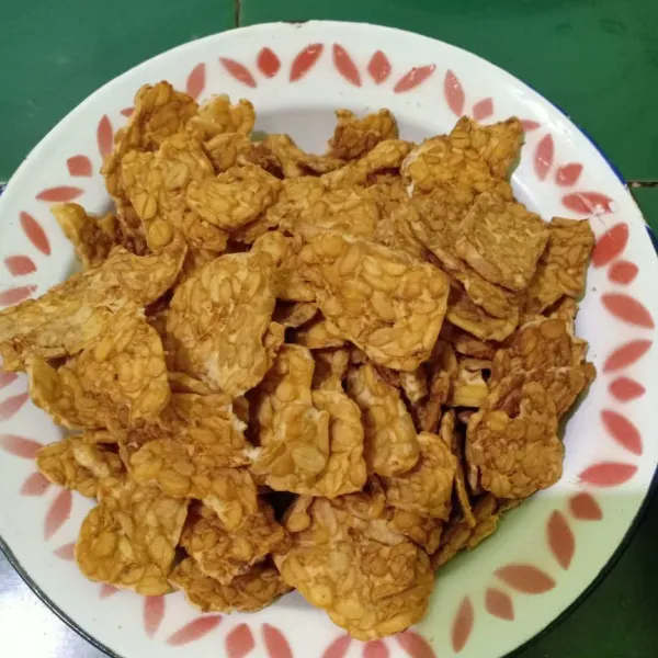 Iris tipis tempe dan goreng sampai kering.