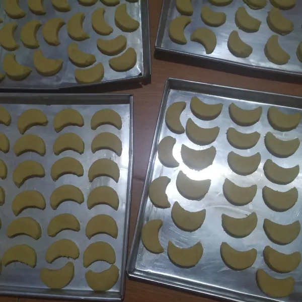 Gilas adonan dengan rolling pin, cetak lalu tata di loyang yang dioles sedikit margarine.