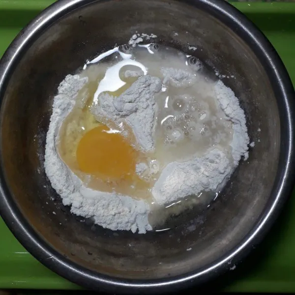 Masukkan telur dan air,secukupnya saja hanya sampai adonan bisa di ulen,aduk rata.