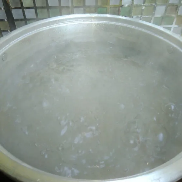 Isi dandang atau panci besar dengan air yang banyak, hingga mampu merendam seluruh ketupat.