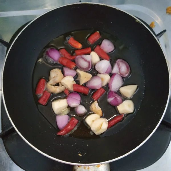 Goreng bawang merah, bawang putih,cabai merah keriting dan kemiri sampai layu.