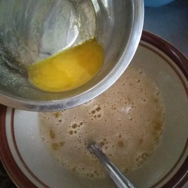 Masukkan mentega cair ke dalam kocokan telur.